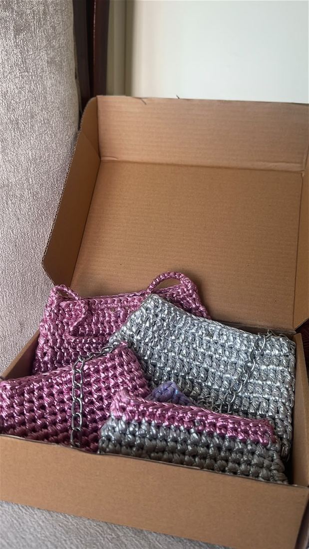 Finished pink, silver and lilac crochet bags in a kraft box