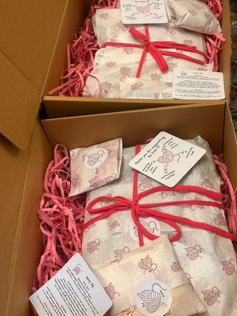 Two kraft boxes with pink paper shred, stamped tissue and thank-you cards